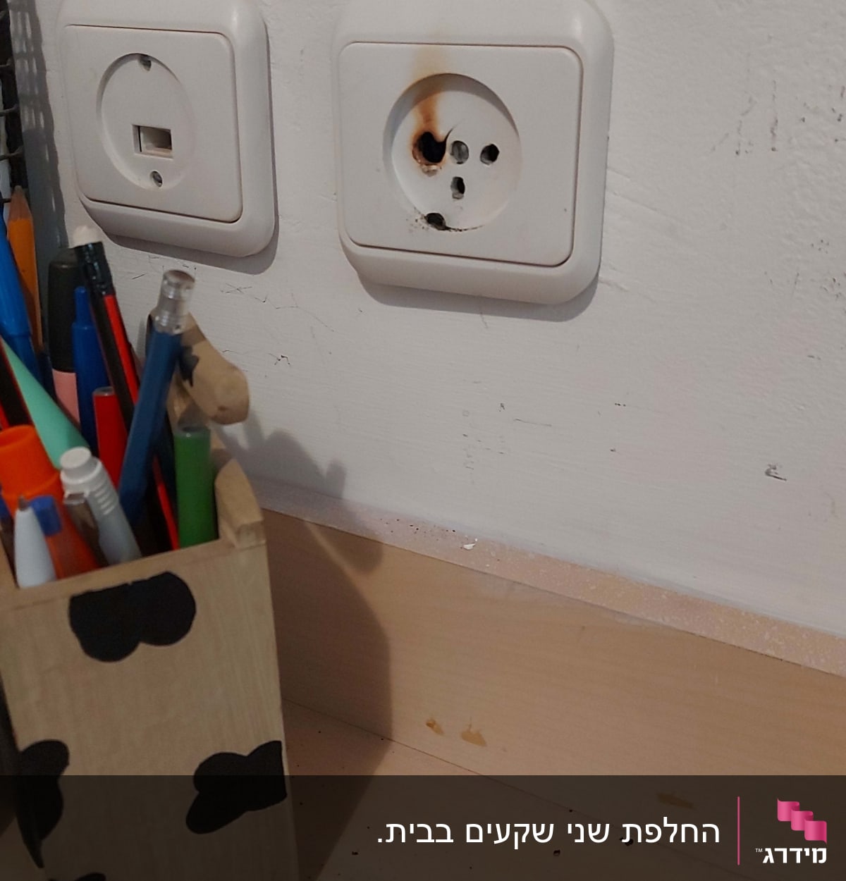 שקע חשמל עם סימני שריפה על הקיר